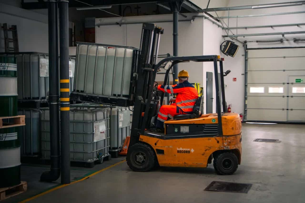 Operator wózka widłowego podczas transportu palety w magazynie